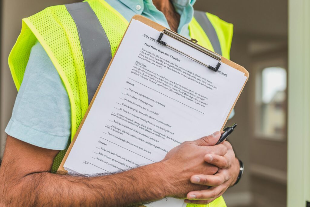 A home inspector holds a home inspection checklist in their hands.